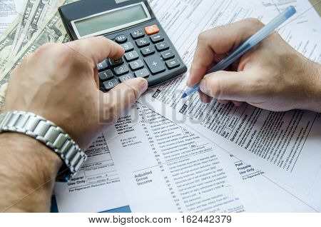 Cropped image of Businessman calculating and checking tax