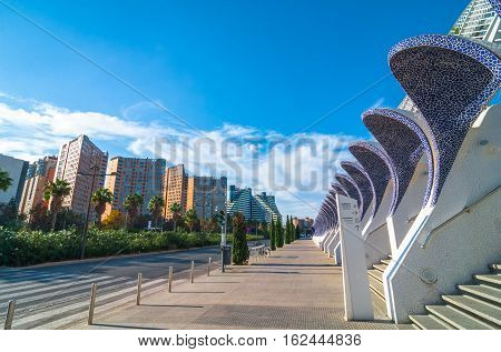 Cityscape and skyline in Valencia, Empty sidewalk along the avenue in Valencia, Spain, featuring modern architecture of ceramic tiled stone bonnets over staircases.