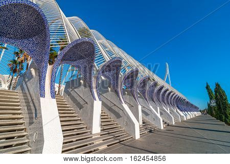 Empty sidewalk along the avenue in Valencia, Spain, featuring modern architecture of ceramic tiled stone bonnets over staircases at the entrance to the city arts centre.