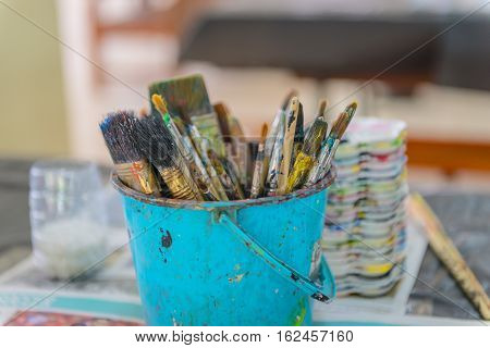Artist Paintbrushes In Dirty Bucket.