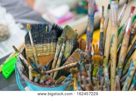Artist Paintbrushes In Dirty Bucket.