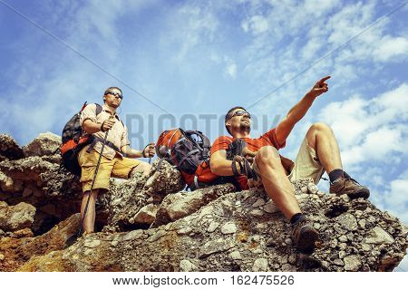 Two men in the beautiful mountains with backpacks and tents.