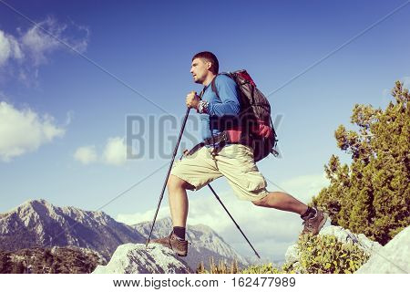 Summer hiking in the mountains with a backpack .