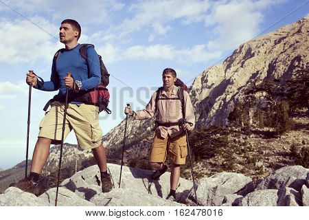 Summer hiking in the mountains with a backpack .