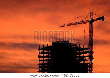 Silhouette of construction crane in downtown development project