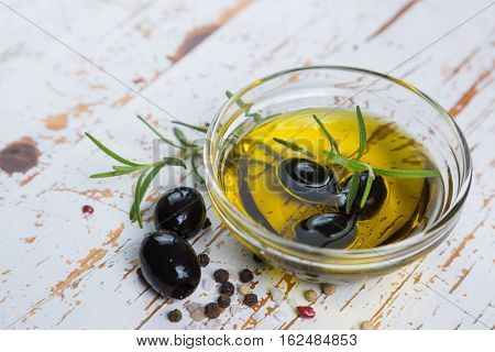 Olive oil with maslines on wood background, copy space