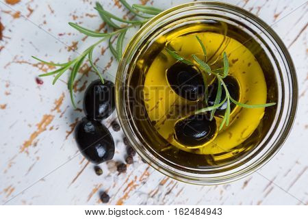 Olive oil with maslines on wood background, copy space