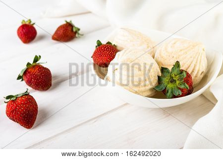 tasty zephyrs on white wooden table. sweet zephyrs and strawberry on wood background.