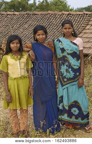 MANDU, INDIA - NOVEMBER 17, 2008: Trio of young Indian women wearing colourful sari's on a farm inside the hilltop fort of Mandu in Madyha Pradesh, India.