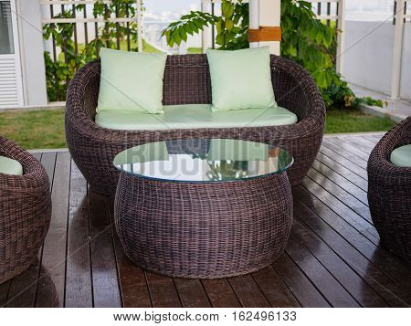 Patio Furniture set with green pillow int the garden