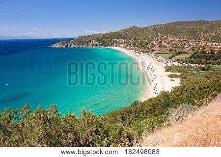 Aerial view on the beach Solanas with white sand hills with green vegetation sea with blue transparent water and village in the province Sinnai. Location Sardinia Italy.