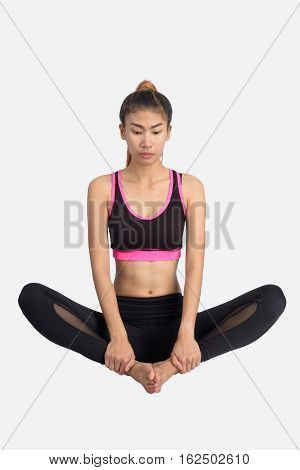 Asian woman training in yoga Baddha Konasana (Bound Angle Pose) isolated on white background.