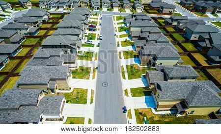 Bird's eye view over Modern Suburban Neighborhood in Austin Texas with rows of cookie cutter houses in a nice suburbia community