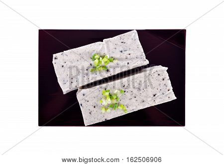 tofu mix black sesame seeds on black plate with white background
