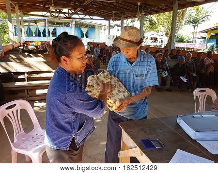 CHIANG RAI THAILAND - DECEMBER 19 : Unidentified asian officer giving old people suffering from leprosy clothing on December 19 2016 in Chiang rai Thailand.