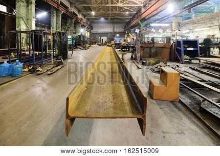 Rusty steel I-beams. Plot welding machine factory.