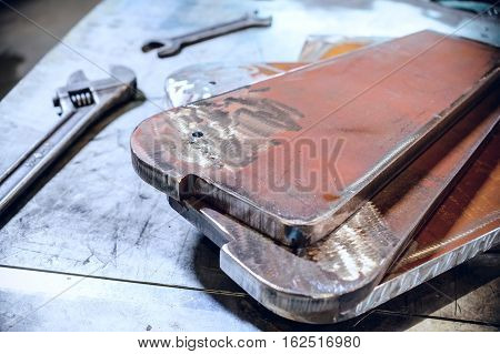 Adjustable and open-end wrenches. Steel metal plate stacked. Abstract industrial background.