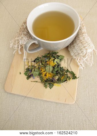 Cup of herbal tea with marigold and cornflower