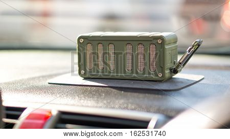 Bluetooth speaker and car entertainment device concept - Green color bluetooth speaker on car console with traffic jam and copy space