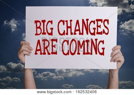 Big changes are coming card in hand with sky background