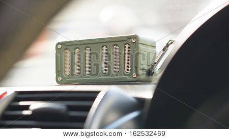 Bluetooth speaker and car entertainment device concept - Green color bluetooth speaker on car console with traffic jam and copy space