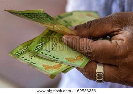 Closeup photograph of hands counting srilankan rupies