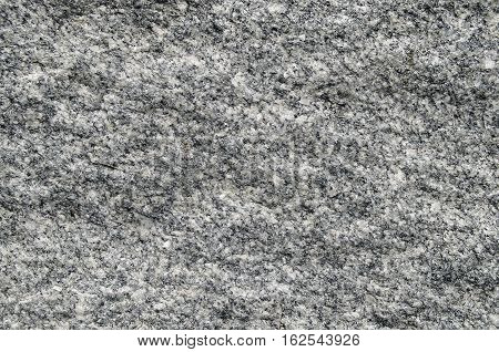 Natural stone grey granite background. Bright hard grey granite rock texture. Grey granite stone background. Grey granite untreated surface. Facing material full frame horizontal texture. Gray granite texture background. Natural stone gray granite backgro