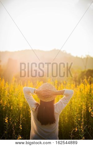 portrait of happy beautiful happy youngwoman relaxing in park. Joyful female model breathing fresh air outdoors and enjoying smell in a flower spring or summer garden vintage tone.