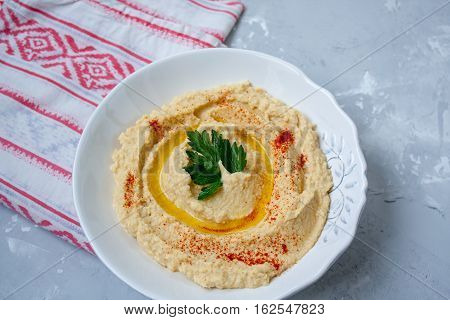 Home classic hummus with celery pitoy.Vid top on gray concrete background. Vegan Food Concept.