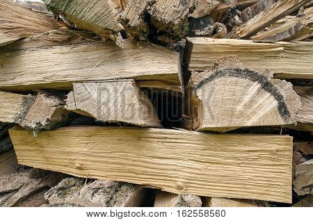 Stack of cut and stacked firewoods background. Closeup photo with visible grain and texture of wood.