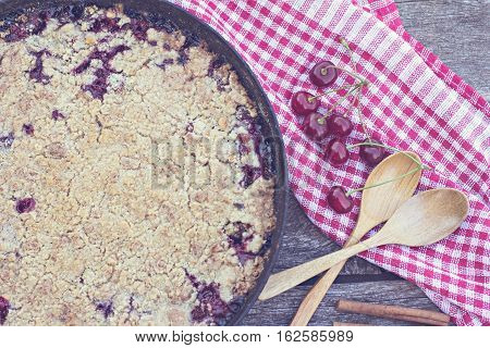 Homemade Cherry crumble and cherries on an old wooden table background.Selective focus.