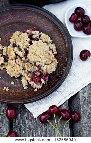 Homemade Cherry crumble and cherries on an old wooden table background.Selective focus.