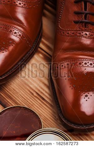 Shoe care. Shoe wax and brushes on wooden surface. Glacage shoes. Oxfords.waxing.Bull shoes.Finger polish.