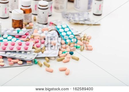 Stack Of Pills And Containers On White Background