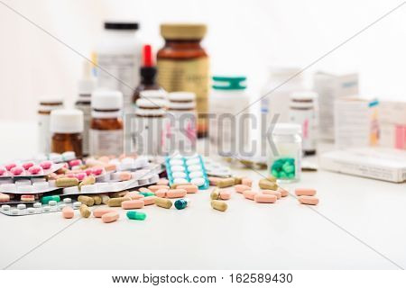 Stack Of Pills And Containers On White Background