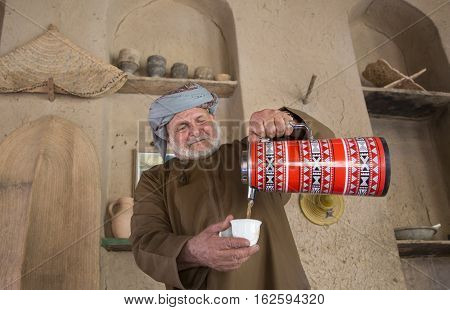 Nizwa Oman December 15th 2016: Omani man serving arabic coffee