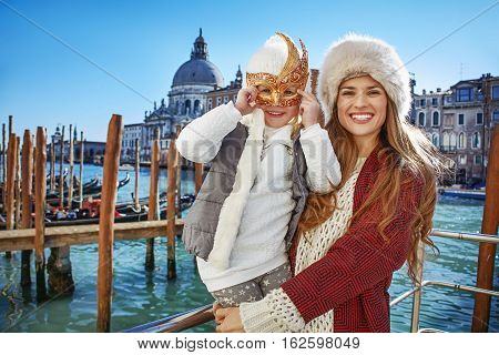 Mother And Child Tourists In Venice Wearing Venetian Mask