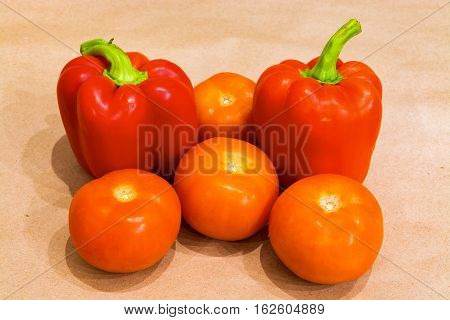 Red pepper with tomato on craftool background closeup