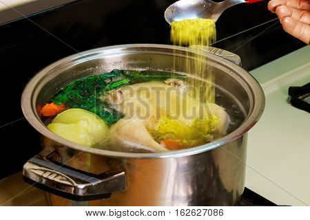chicken broth carrots chicken green Chicken soup in a bowl with crackers.