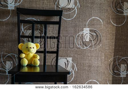Yellow bear doll sitting on the chair, lonely yellow bear doll, single doll