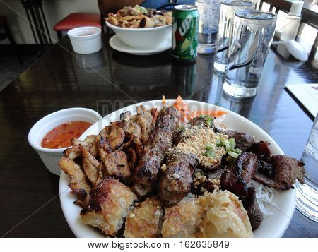 Vietnamese Vermicelli Noodle Bowl Food Dish With Meatballs and chicken and crispy spring rolls