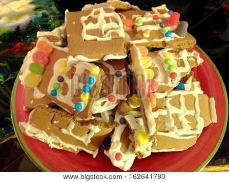 A beautiful picture of a plate of Christmas Cookies From a broken up Gingerbread House.