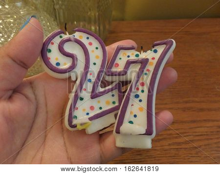 Melted Number Twenty Seven Birthday Candles In a Hand