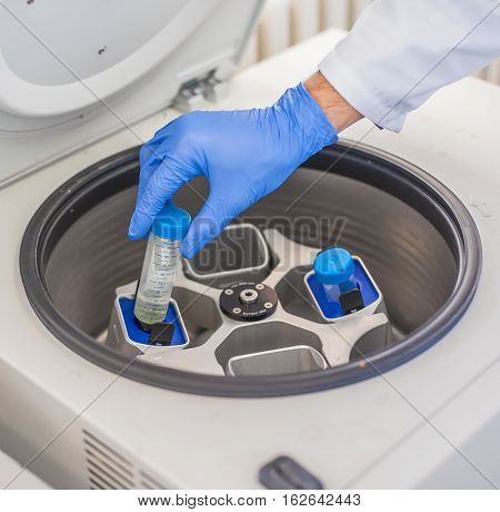 Technician Loading A Sample To Centrifuge Machine