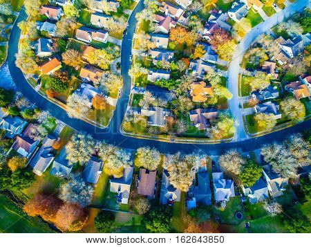 Aerial View Over Modern Suburb Home Community neighborhood with colorful Fall Autumn trees around curved streets and new development outside of Austin , Texas looking straight down