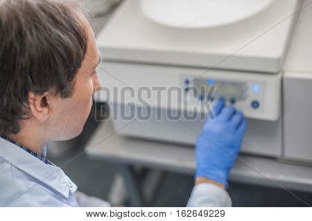 Technician Uses The Centrifuge Machine