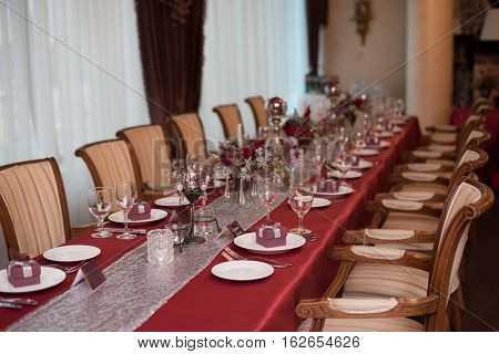 restaraunt tables with red tablecloth, red wedding decor, table of newly married