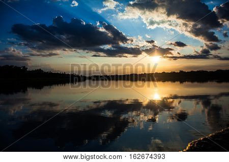 Reflection of the sun at sunset in the Limoncocha lagoon in the Ecuadorian Amazon