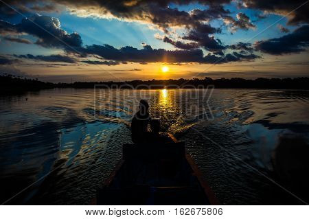 Reflection of the sun at sunset in the Limoncocha lagoon in the Ecuadorian Amazon