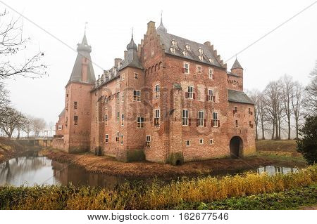 Medieval Doorwerth Castle   on the river Rhine near the city of Arnhem on a foggy winter day, Netherlands.